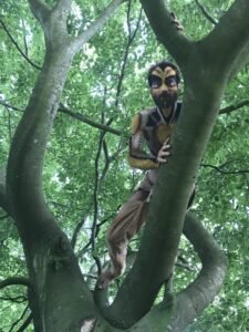Xavier Auclair with tribal-style body paint in a tree - Homme avec peinture de type tribal dans la nature qui est monté dans un arbre