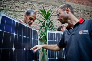 KarmSolar team inspecting newly received solar photovoltaics panels - KarmSolar inspectant des panneaux solaires photovoltaïques nouvellement reçus