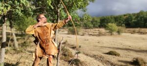 Xavier Auclair shooting a primitive wooden bow